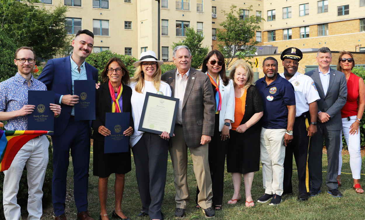 LGBTQ+ Health & Wellness Center Program Specialist Finn Schubert, LGBTQ+ Health & Wellness Center Christopher Awwad, Bergen New Bridge Medical Center President and CEO Deborah Visconi, Mayor of Glen Rock Kristine Morieko, Bergen County Executive James J. Tedesco III, Commissioner Vice Chairwoman Germaine Ortiz, Commissioner Mary Amoroso, Commissioner Rafael Marte, Bergen County Sheriff Anthony Cureton, and Bergen County Prosecutor Mark Musella pose for photos with a Pride Month proclamation.